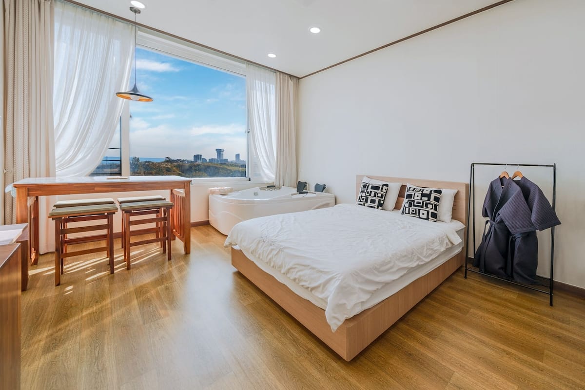 Een moderne hotelkamer met een groot bed, een bureau en uitzicht op de stad.
