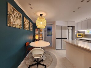 Enjoy meals in the kitchen and dining area, featuring a round table and a stainless steel sink.