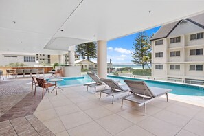 An indoor swimming pool area with lounge chairs and a bar. - Luxury Hinterland View on Palm Beach (Palm Beach)