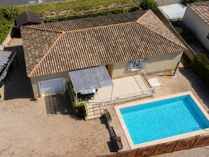 Une propriété résidentielle dotée d’une piscine, d’un patio couvert et d’un garage.