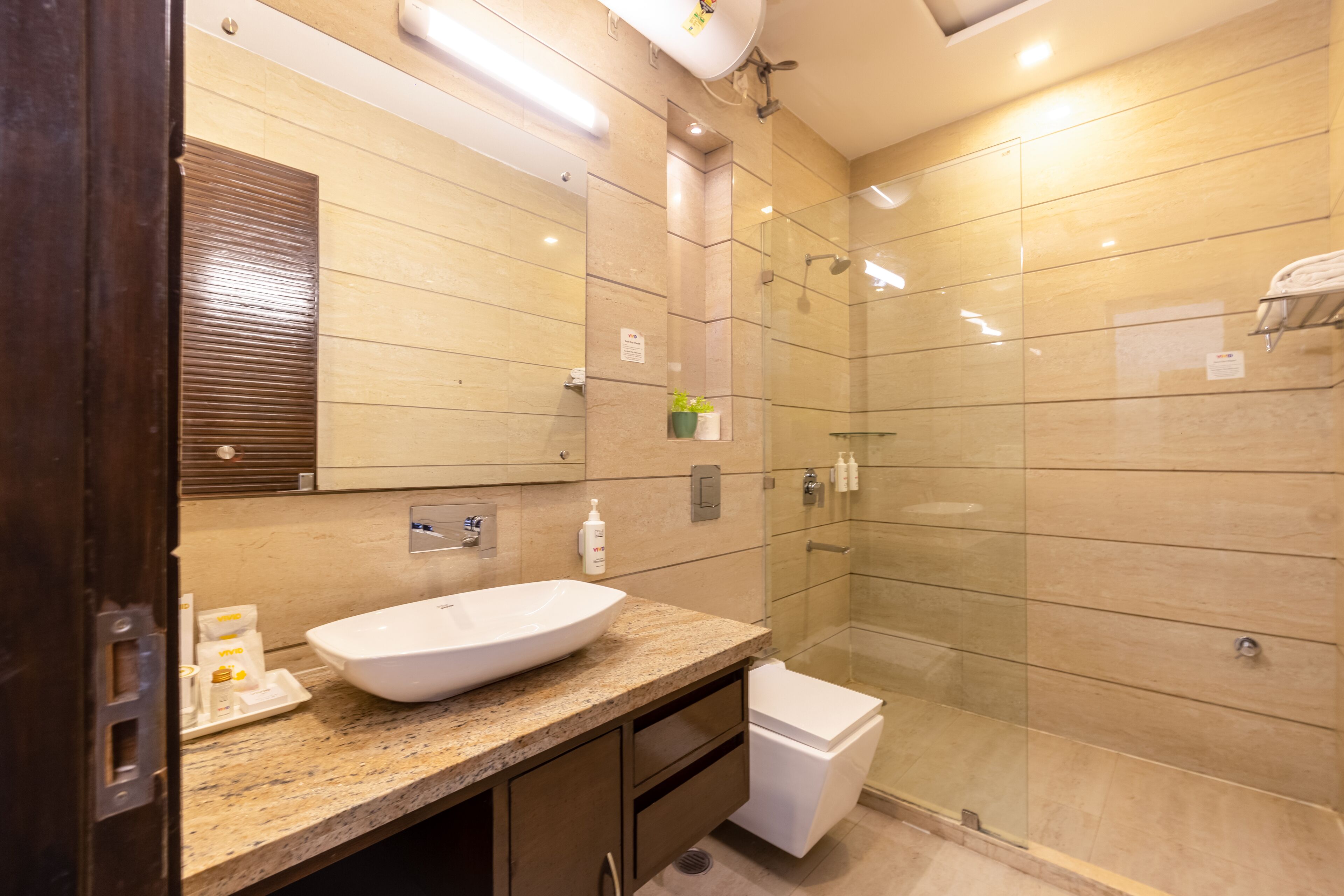 Une salle de bain moderne avec un grand lavabo, un miroir et une douche en verre.