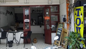 A storefront named 'GRAVITY' with a 'Sorry we're CLOSED' sign, outdoor seating, a scooter, and a 'TAN' sign.