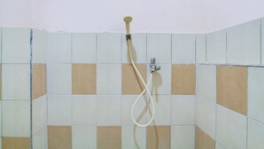 A shower with a hose and a handheld showerhead mounted on the wall. - Collection O Simpang Lima Near Simpang Lima Semarang Formerly Hotel Eben Haezer (Semarang)