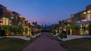A pathway leading to a modern building complex with multiple units, surrounded by well-maintained greenery and palm trees. - Private Villa Ayra 9C 10min MelastiBeach (Ungasan)
