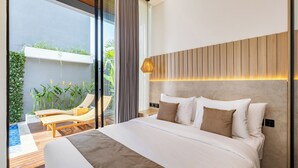 A modern bedroom with a large bed, a wooden headboard, a bedside lamp, and a view of a balcony with plants and a chair. - Private Villa Ayra 9C 10min MelastiBeach (Ungasan)