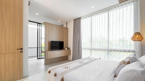 A modern hotel room with a large bed, a flat-screen TV, and a balcony with a view. - Private Villa Ayra 9C 10min MelastiBeach (Ungasan)