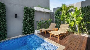 A modern outdoor pool area with two wicker lounge chairs, a wooden deck, and lush greenery. - Private Villa Ayra 9C 10min MelastiBeach (Ungasan)
