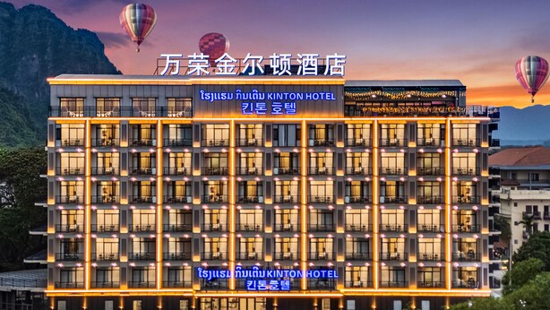 Een hotel met meerdere verdiepingen, een moderne gevel, balkons en een zwembad.