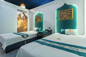 A hotel room with two beds, teal headboards, and artwork on the walls. - Kinton hotel (Vang Vieng)