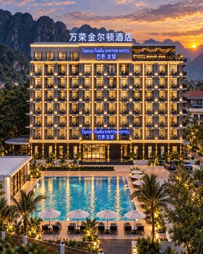 Un hôtel à étages, doté d’une piscine et d’espaces extérieurs aménagés pour se détendre.