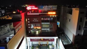 A multi-story building with a sign for 'Raj Plaza' and 'The Park Residency Hotel'.