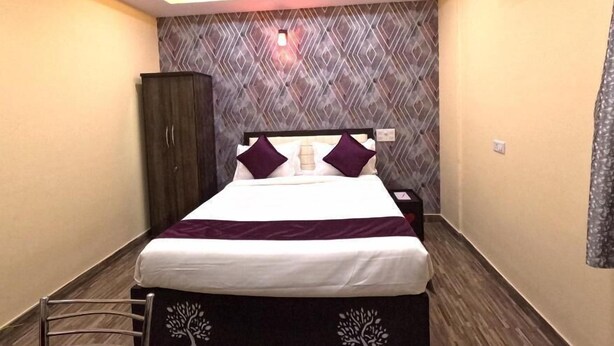 A modern bedroom with a bed, a wardrobe, a nightstand, and a ceiling fan.