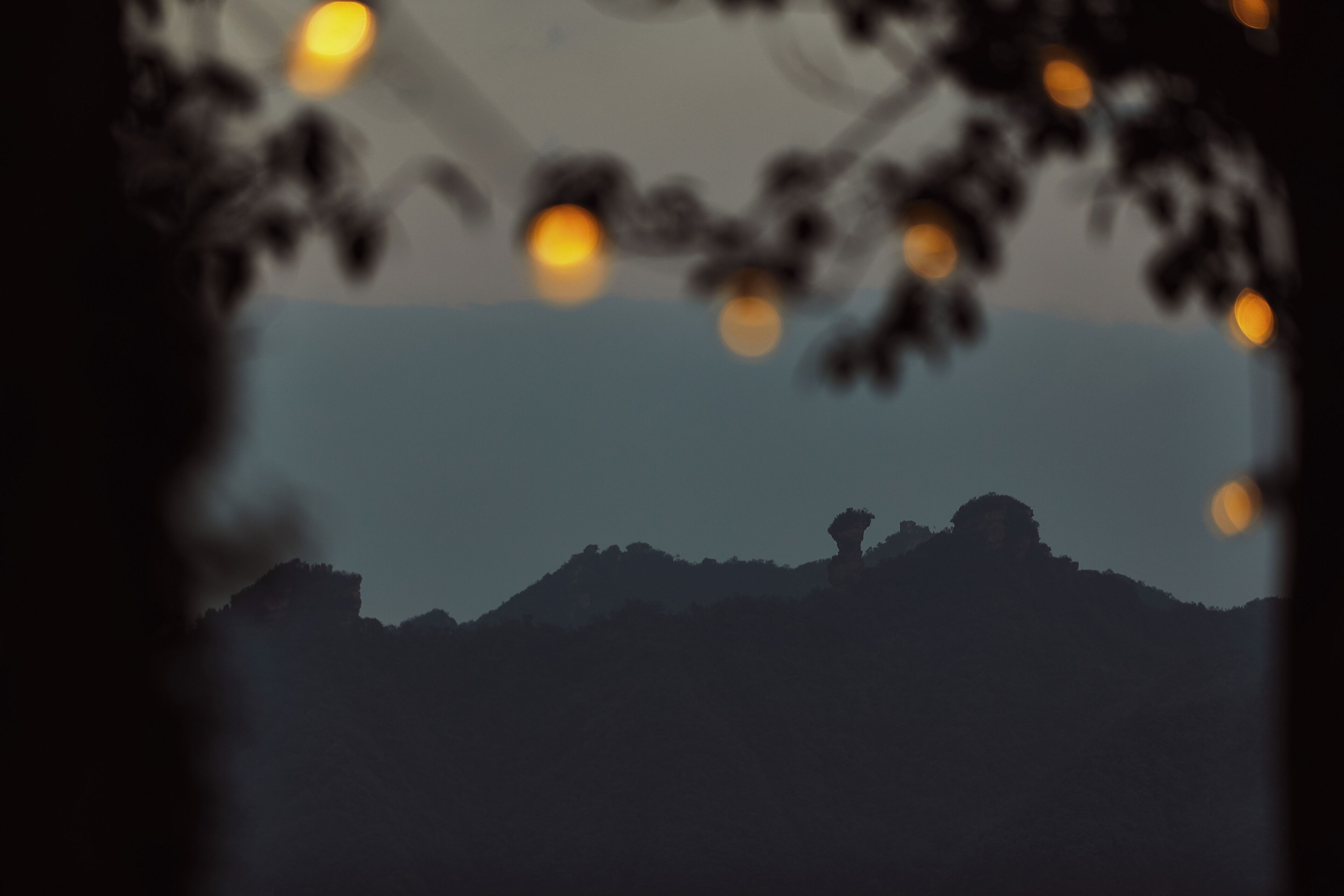 A silhouette of a mountain range with a prominent peak.
