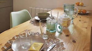A dining area with a table set for two, a window with a view, and a radiator.