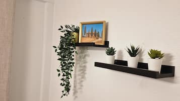 Een wandplank met een lijstfoto en drie planten in potten.