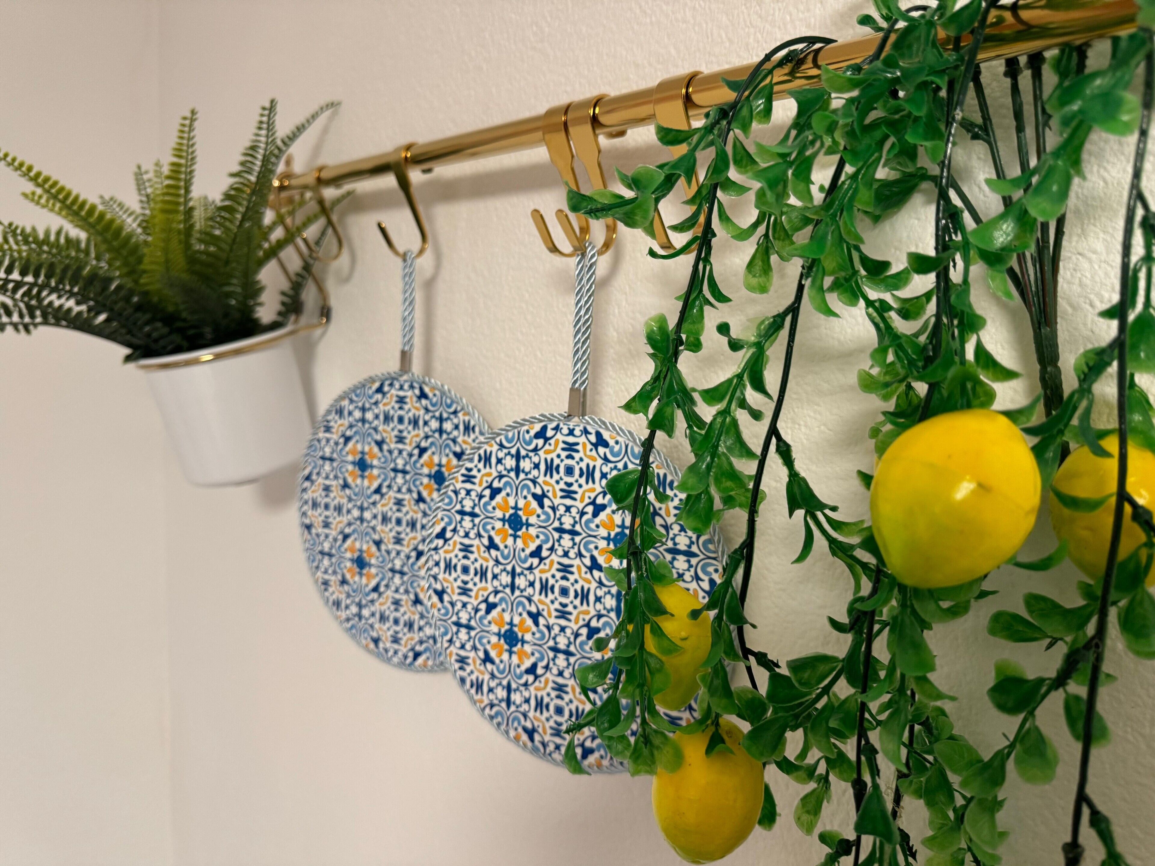 A wall-mounted rack with a potted plant, two heart-shaped ceramic pieces, and hanging artificial plants with yellow leaves.