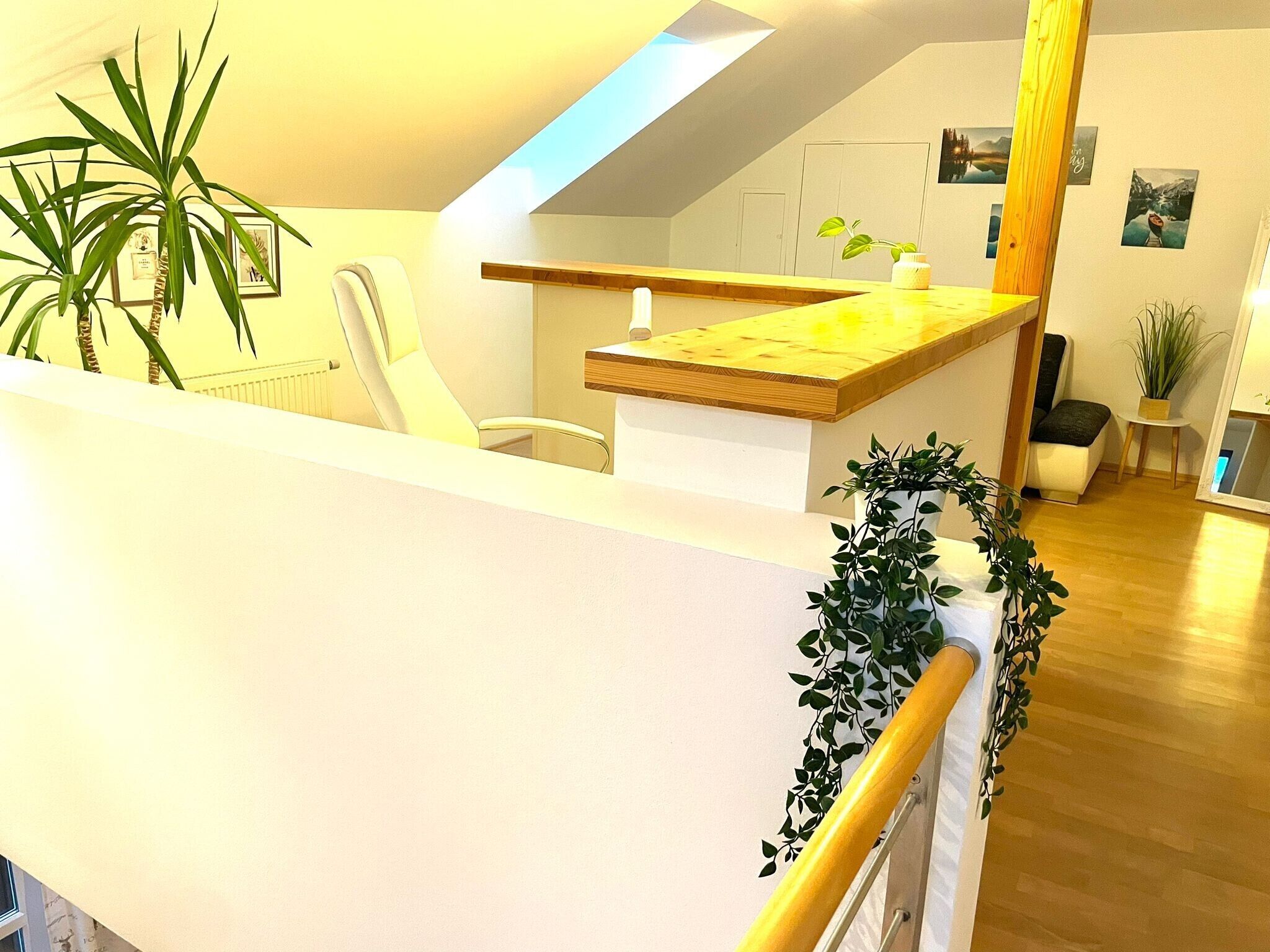 Ein modernes Interieur mit einer Holztresen, einem weißen Stuhl und einer Treppe mit Geländer.
