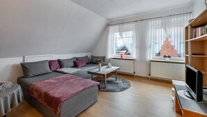 Un salon moderne avec un canapé, une table basse et un meuble pour la télévision.
