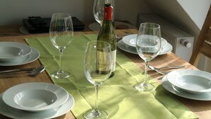 Una mesa de comedor con platos, copas de vino y cubiertos.