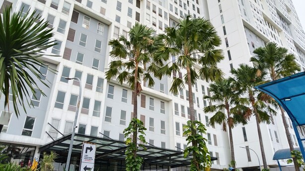 A high-rise building with a modern architectural design, featuring a grid of windows and balconies. - Amerta Room Patraland Urbano (Bekasi)
