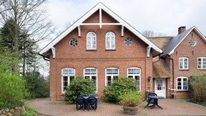 A brick building with a symmetrical facade, multiple windows, and a central entrance. - Apartment 'Große Ferienwohnung' with Shared Terrace, Shared Garden and Wi-Fi (Leck)