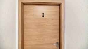 Une porte en bois portant le numéro « 3 » et munie d’un trou de serrure.