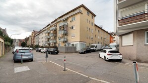 A multi-story residential building with balconies, parked cars, and a clear sky. - Apartment 'Die Edisonstraße' with Wi-Fi (Pforzheim)
