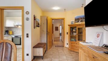 A kitchen with cabinets, a bench, and a dining area with a chair.