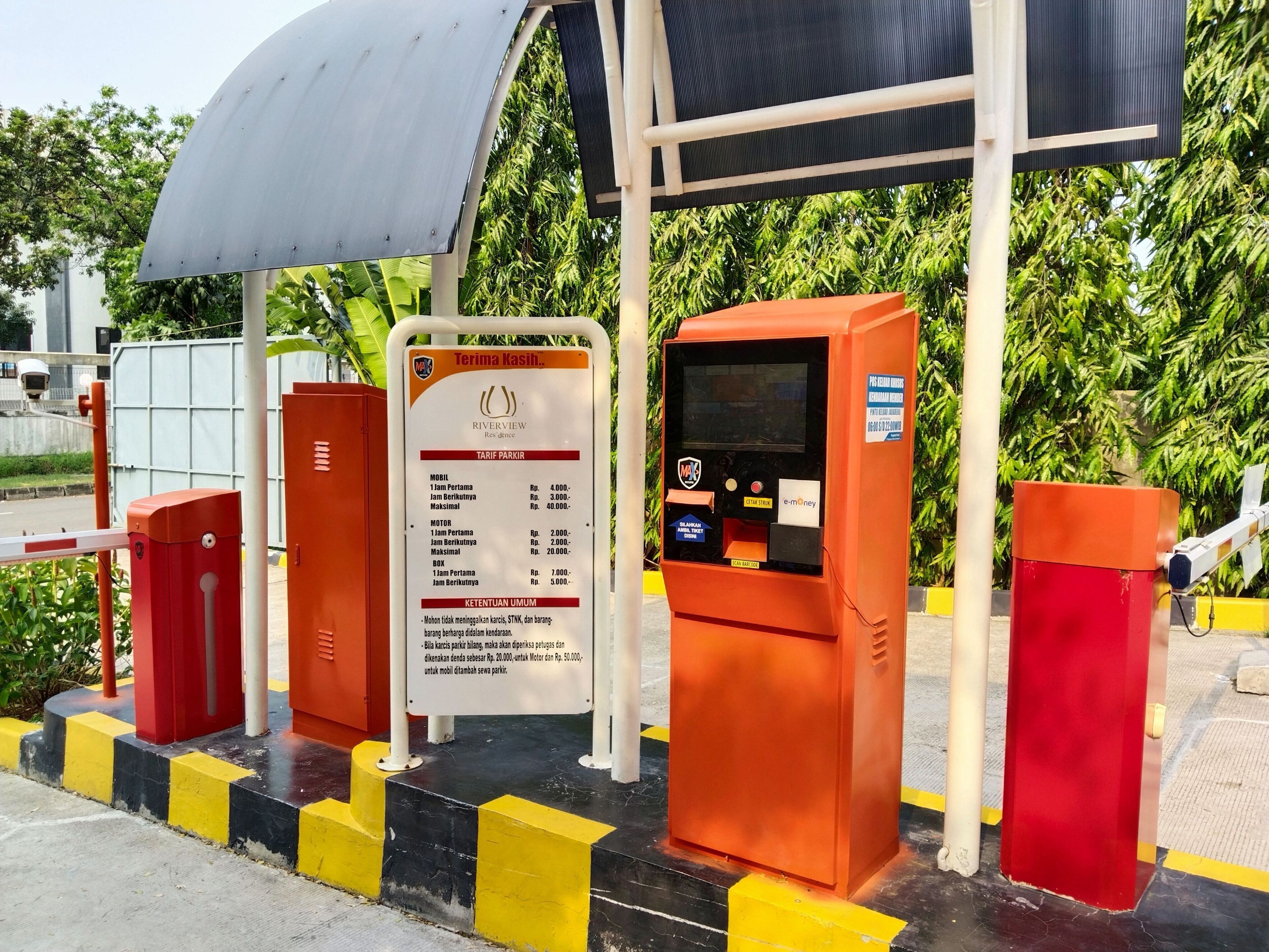 Un quiosco para pagar el estacionamiento, con un cartel que indica las tarifas.
