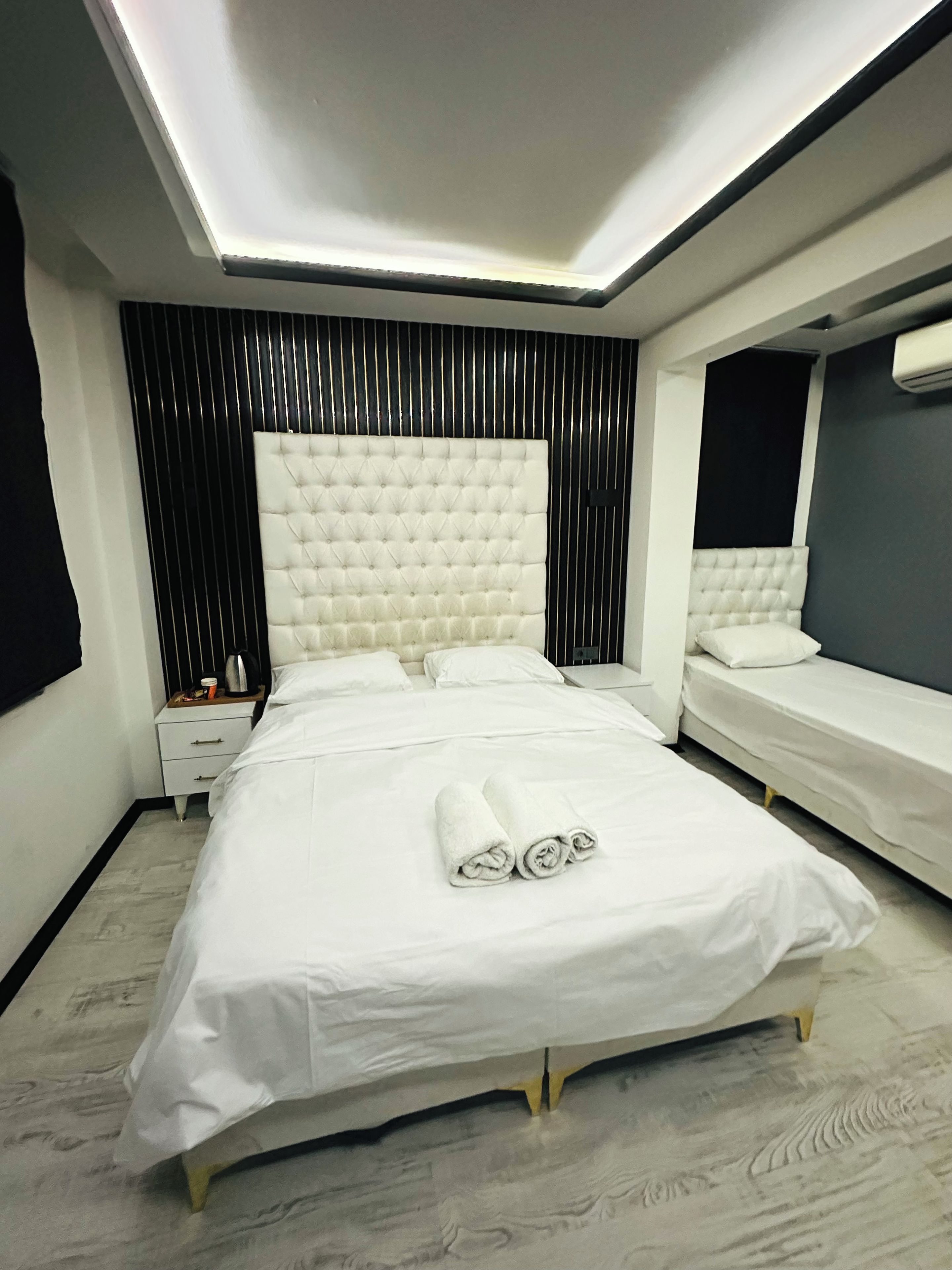 A modern bedroom with a large bed, bedside tables, and a built-in bench.