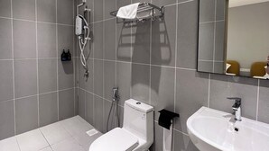 A modern bathroom with grey tiles, a white toilet, a sink, and a shower. - Havona Hotel @ CIQ Johor Bahru - Self Check-In (Johor Bahru)