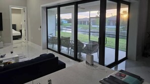 Una sala de estar moderna con un gran ventanal corredero que da a un balcón.
