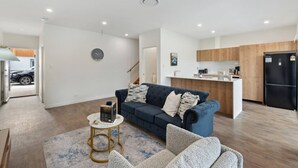 Eine moderne Wohnung mit Wohnzimmer, Küche und einem sichtbaren Auto vor dem Haus.