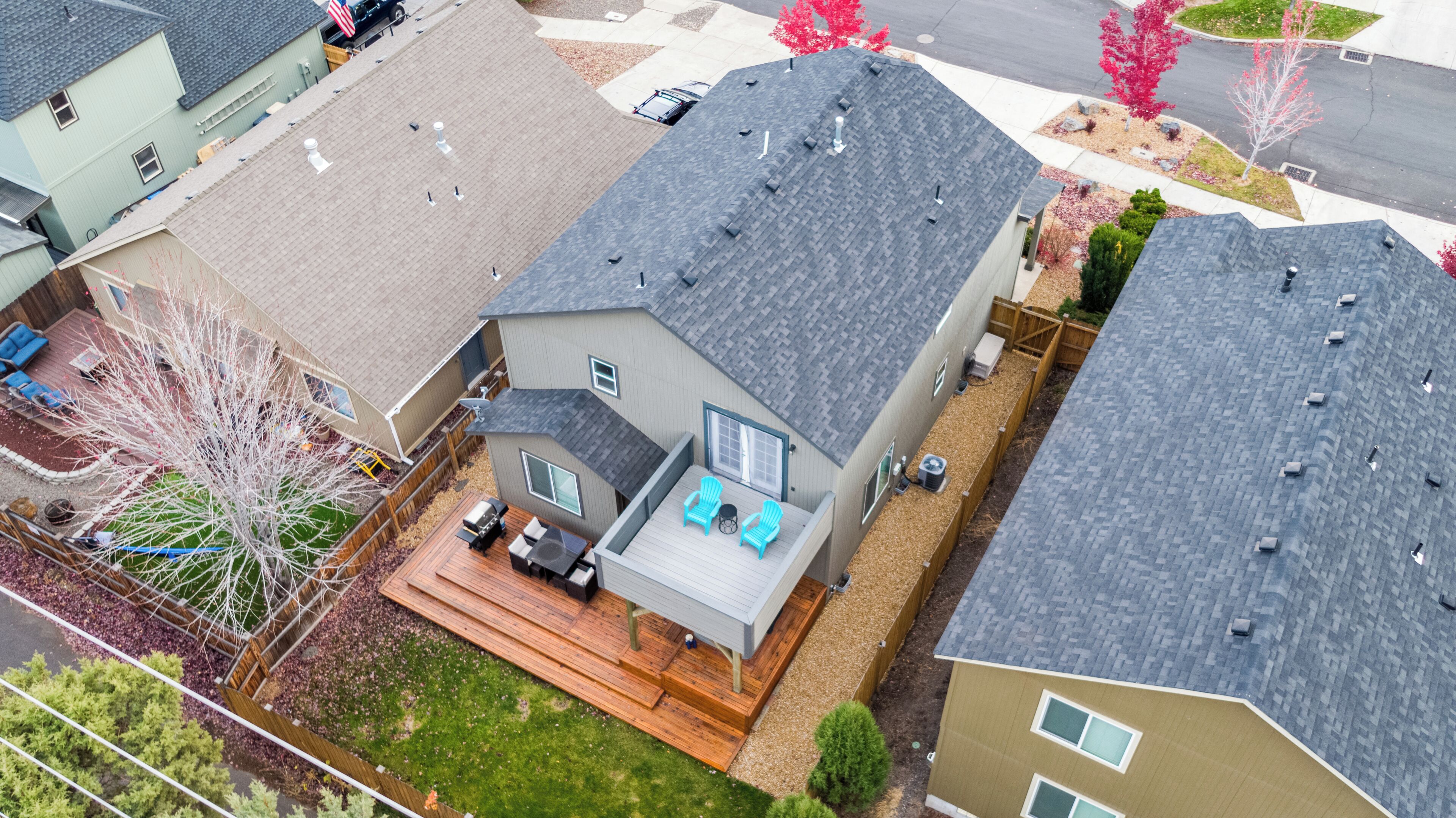 Un quartier résidentiel avec des maisons, une terrasse dotée de mobilier d’extérieur et un petit jardin.