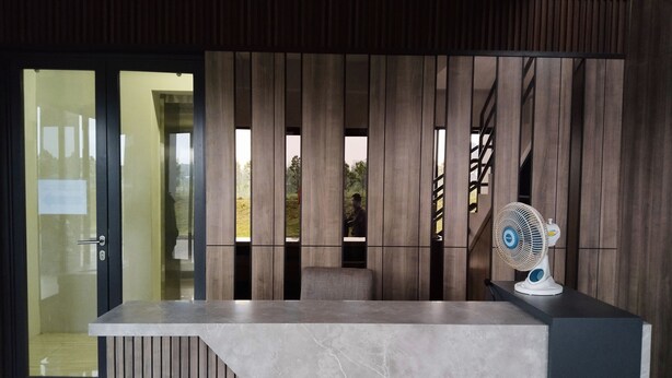 A reception desk with a modern design, featuring a marble countertop and vertical wooden slats.