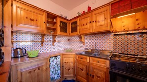 Una cocina con armarios de madera, una estufa y un lavamanos.