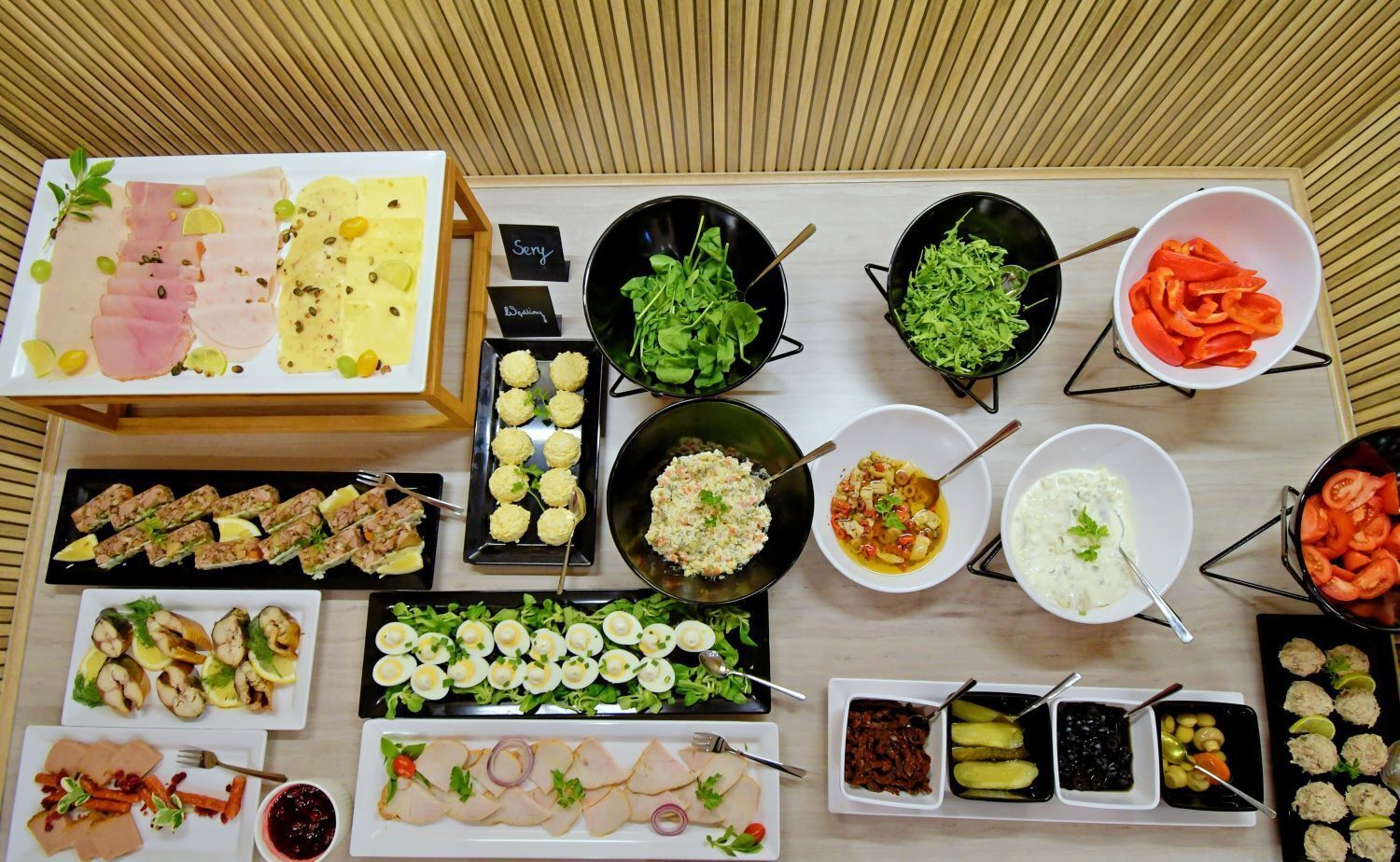 Diversos alimentos e pratos dispostos sobre uma mesa.