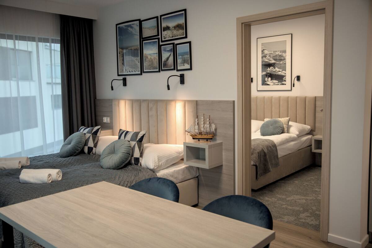 Quarto de hotel moderno com uma cama grande, uma escrivaninha e vista para a cidade.