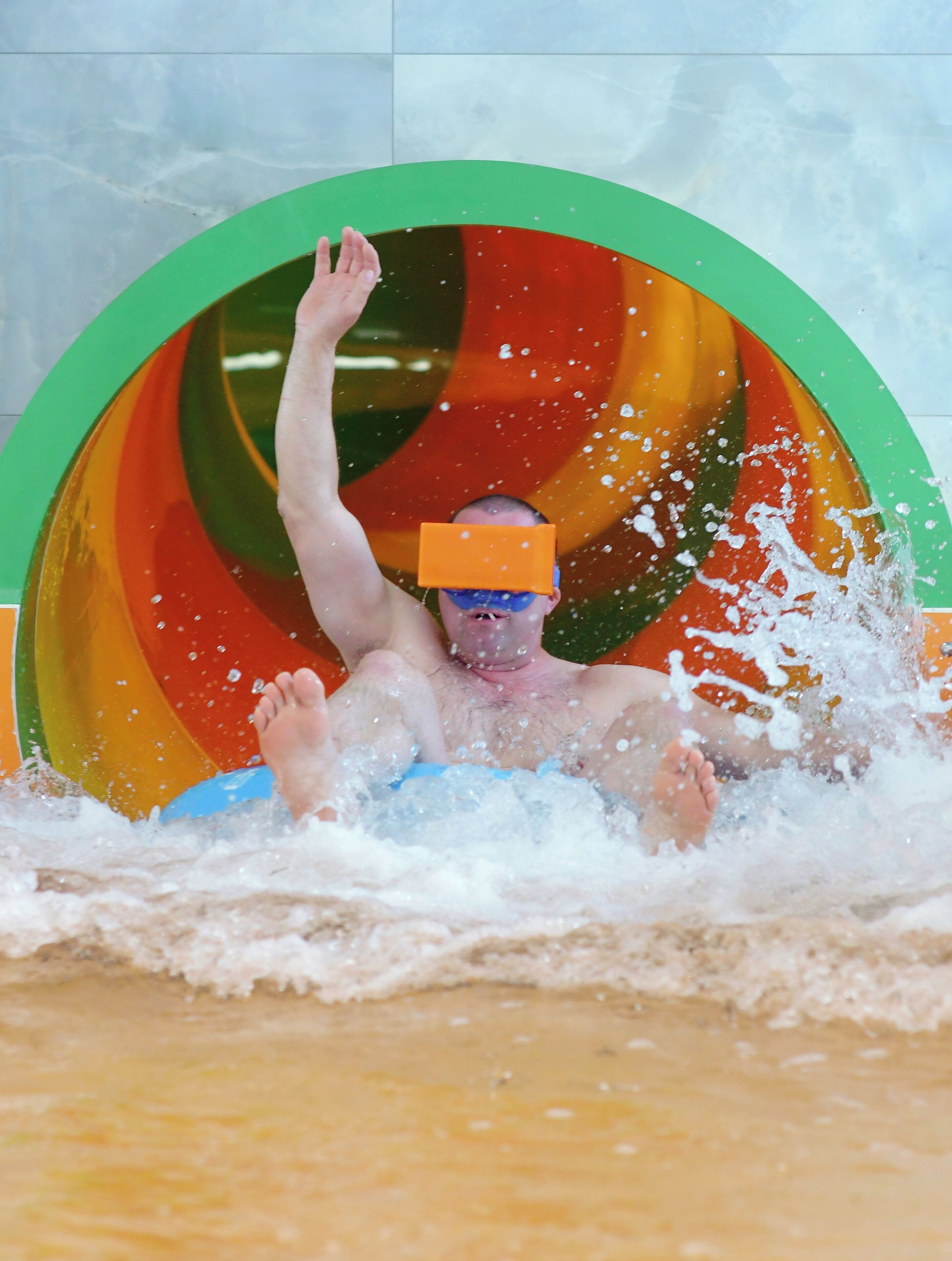 Una persona en un tobogán de agua con un diseño circular y colorido.