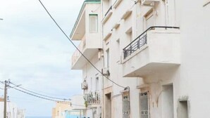 A narrow street with multi-story buildings, balconies, and a visible power line. - Luxurious apartment with sea view in La Marsa (Marsa)