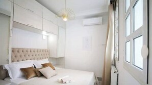 A bedroom with a large bed, a tufted headboard, and a ceiling fan. - Luxurious apartment with sea view in La Marsa (Marsa)