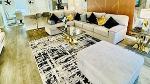 A modern living room with a sectional sofa, a coffee table, and a patterned rug. - Comfort house weekly discount and monthly discount (Cullman)