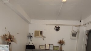 A reception desk with a clock, framed certificates, and decorative plants. - Castle Rock Boracay (Boracay Island)