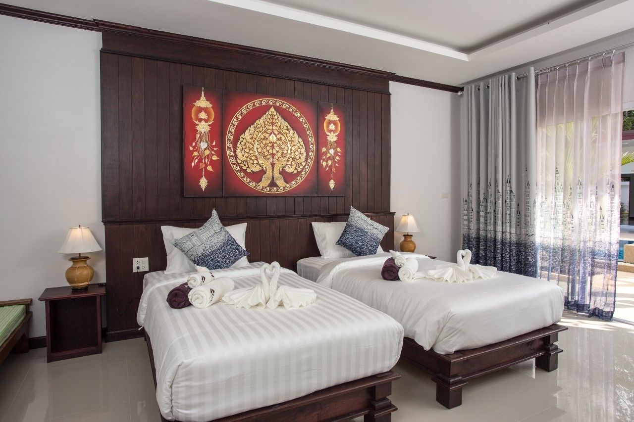 A hotel room with two beds, a dark wood headboard, and a large decorative panel above the beds.