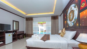 Camera d'albergo con un letto grande, una televisione, un mini-frigorifero e vista su una piscina.