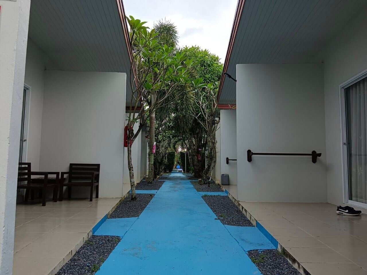 A corridor with a blue carpet, wooden benches, and a pull-up bar.