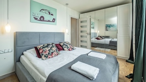 Una camera da letto moderna con un letto grande, un armadio e uno specchio.