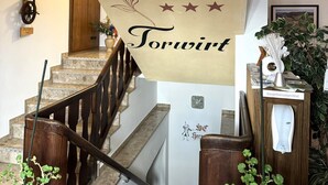 Una escalera con un cartel colgando del techo que anuncia un restaurante.