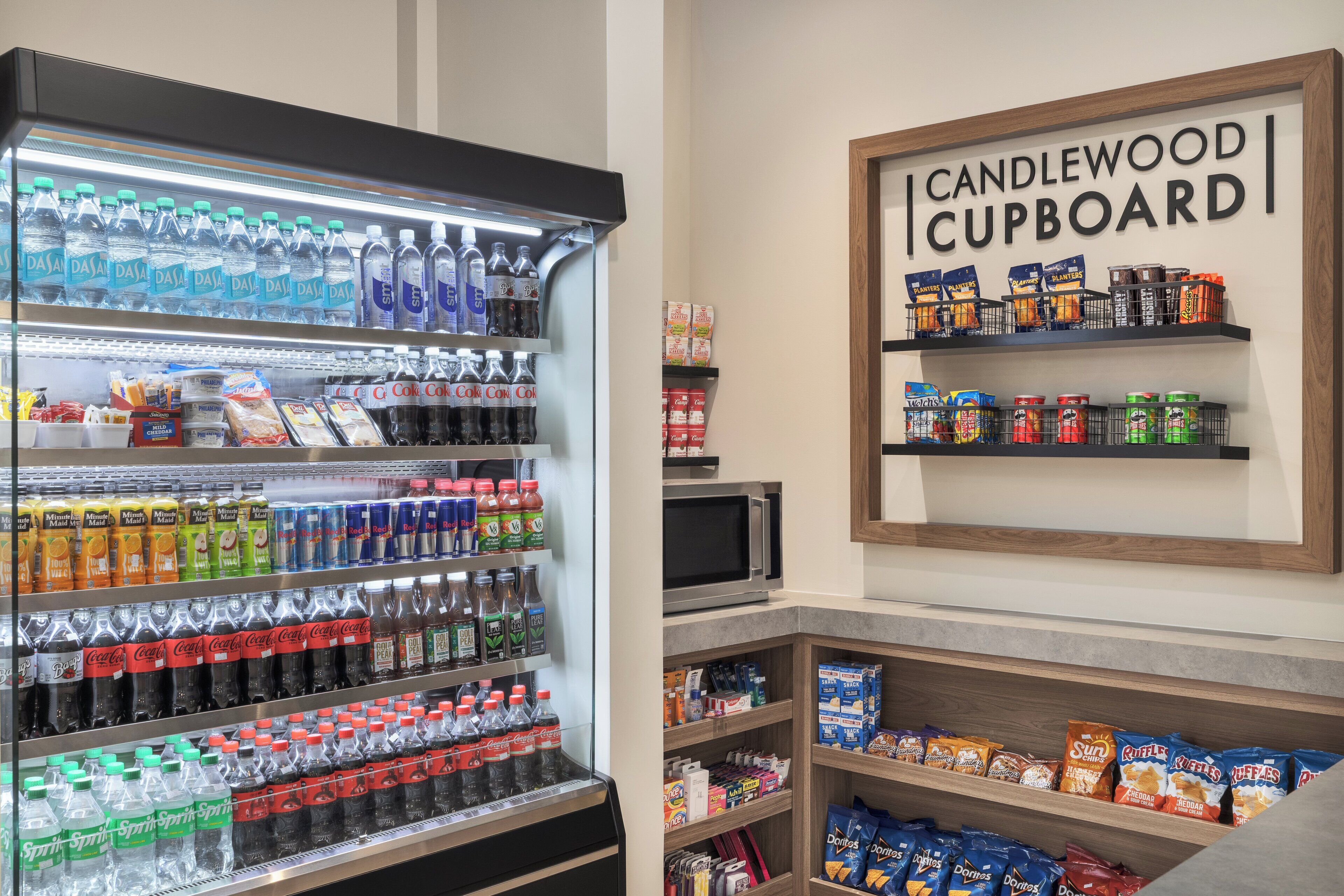 A refrigerated beverage display, snack shelves, and a microwave.