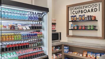 A refrigerated beverage display, snack shelves, and a microwave.
